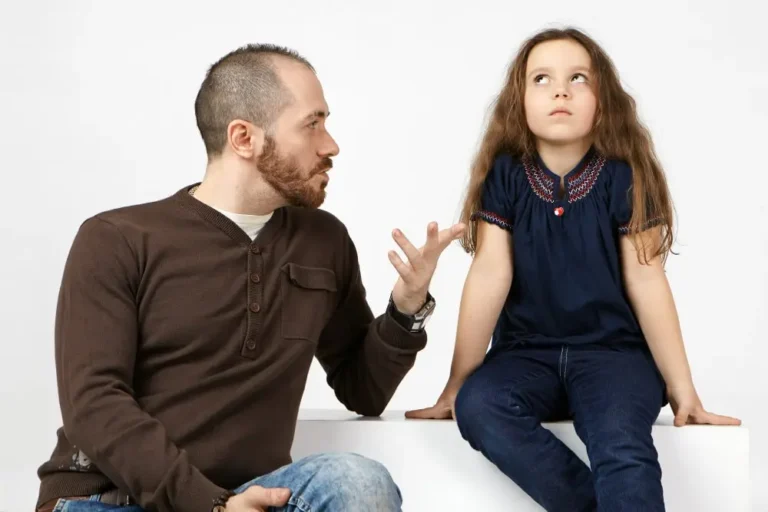 A controlling parent guides his young daughter